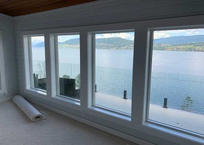 Westside lake view from primary bedroom with carpet flooring